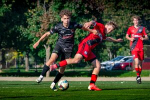 Teenagers engage in an intense soccer match in a Montreal park, showcasing energy and skill.