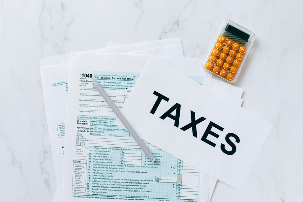 Top view of tax forms, a calculator, and pen for tax preparation.