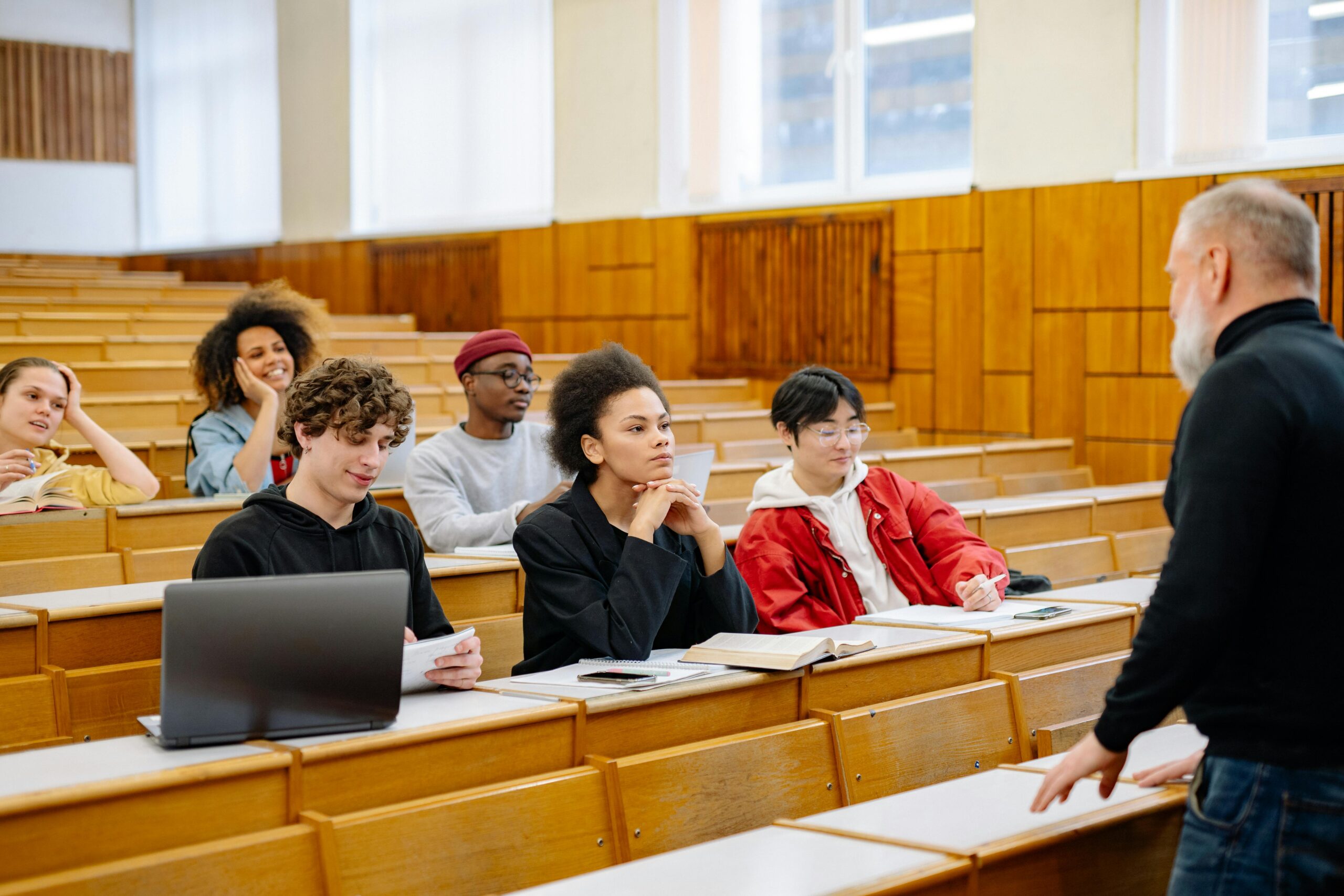 Students from diverse backgrounds engaged in a university lecture setting.